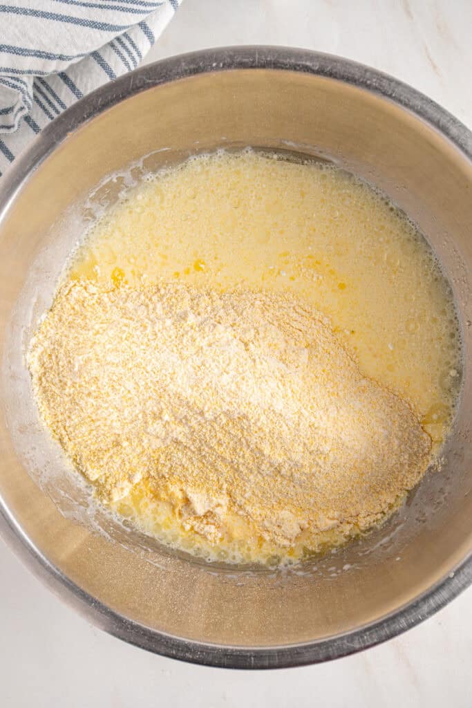 Adding dry ingredients to the wet ingredients to make a batter.