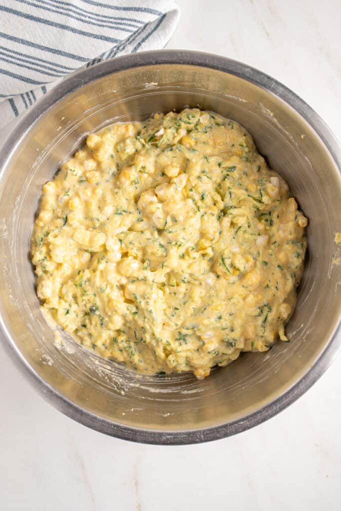 Mixed batter in a bowl to make corn zucchini fritters.