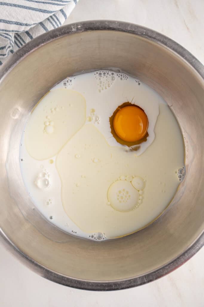 Wet ingredients for making fritters in a bowl.