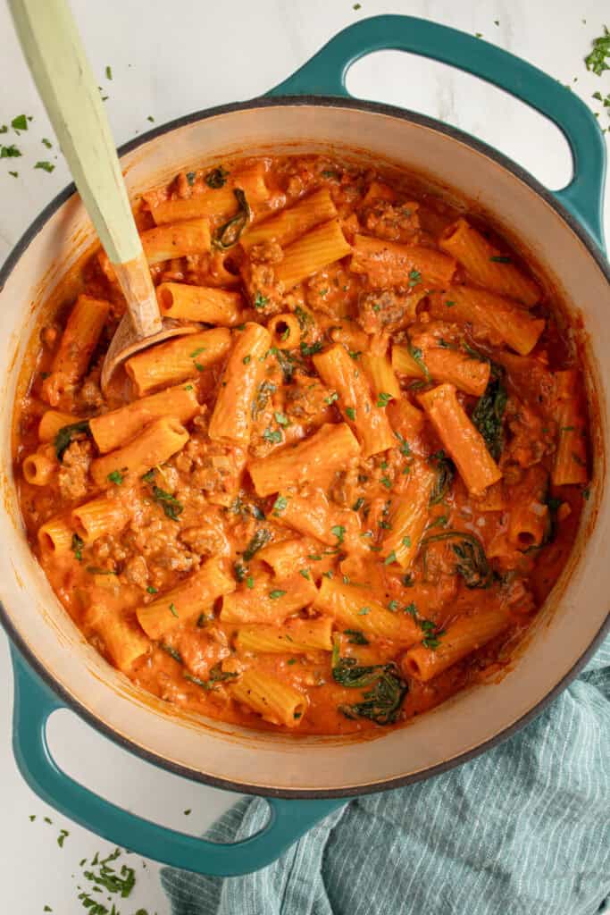 A dutch oven filled with Creamy One Pot Sausage Rigatoni.